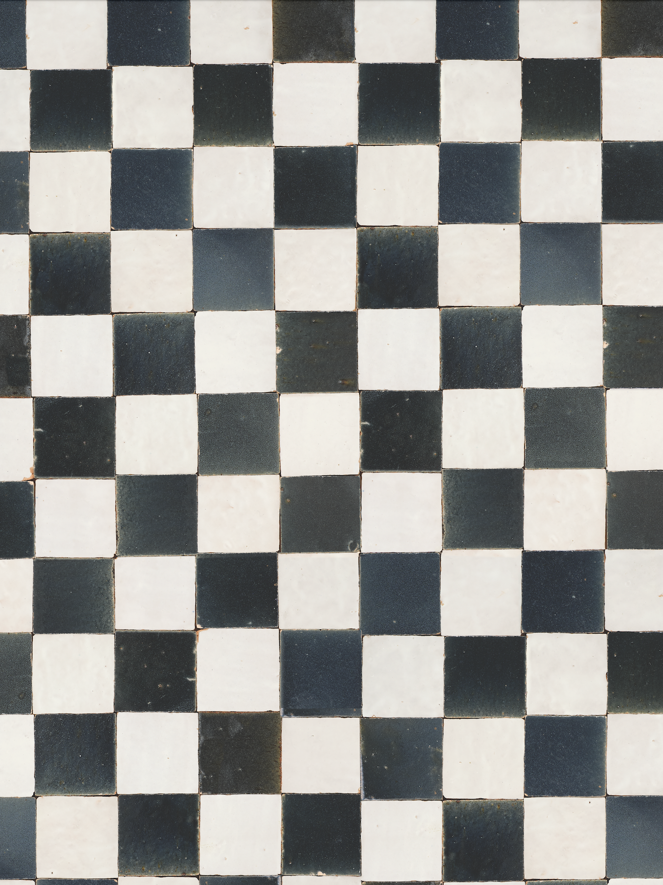 black and white scuffed tile arranged in checkered pattern, no grout